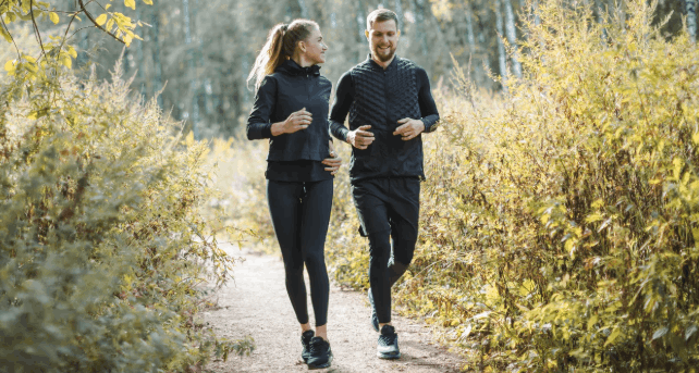 Femme et homme sportifs en extérieur avec un teint lumineux, illustrant les effets du sport sur la peau.